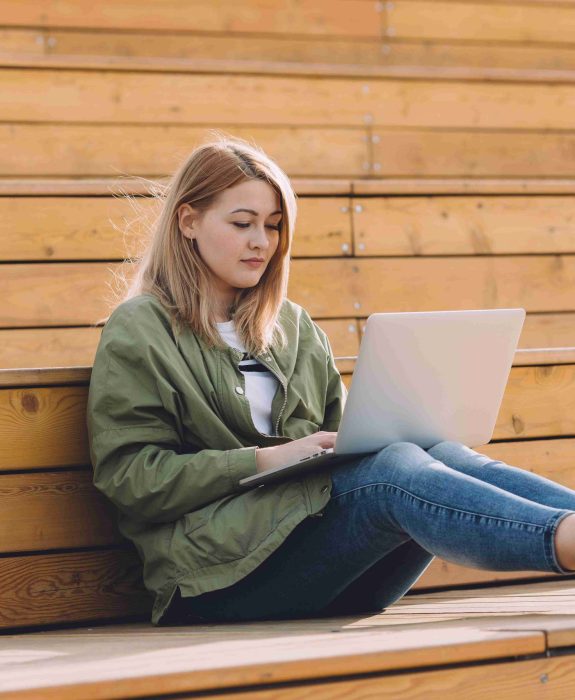 girl-with-a-silver-laptop-on-her-knees-resting-on-EELY35H-scaled.jpg
